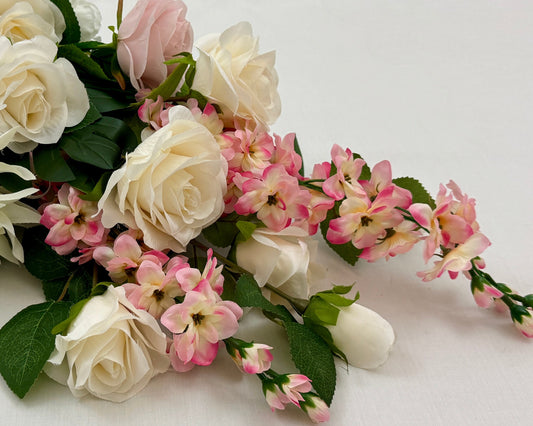 Liggend rouwboeket met roze en witte rozen