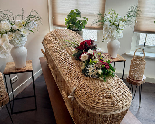 Rieten grafmand met bloemstukken