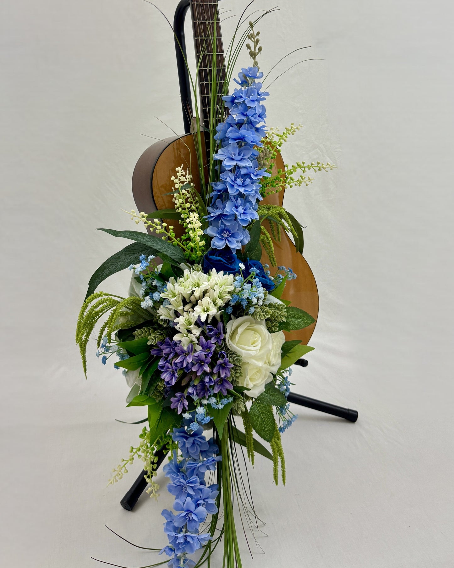 Rouwstuk met blauwe bloemen op gitaar
