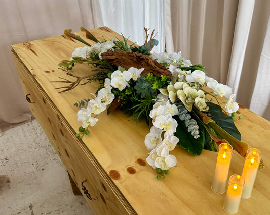 Lang kiststuk met orchideeën en hout op kist met kaarsjes