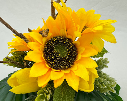 Close up van mini rouwboeket met zonnebloemen en takje