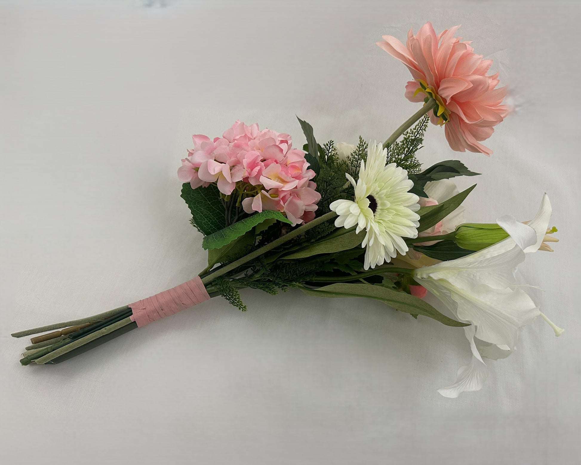 Liggend rouwboeket met roze bloemen