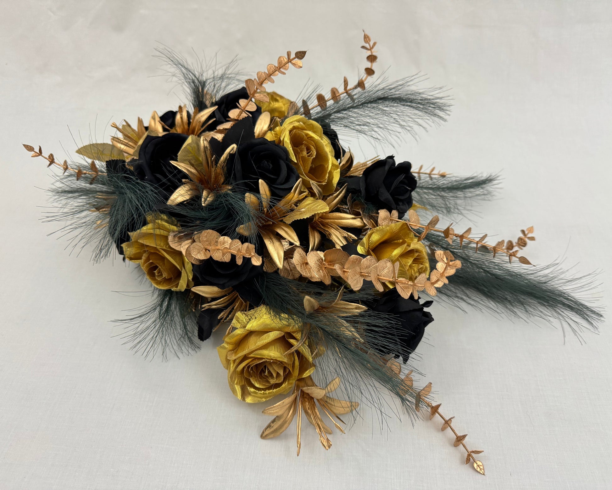 Druppelvormig rouwstuk met gouden en zwarte bloemen