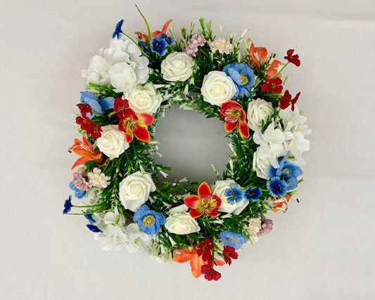 Rouwkrans met rode, blauwe en witte boeketten