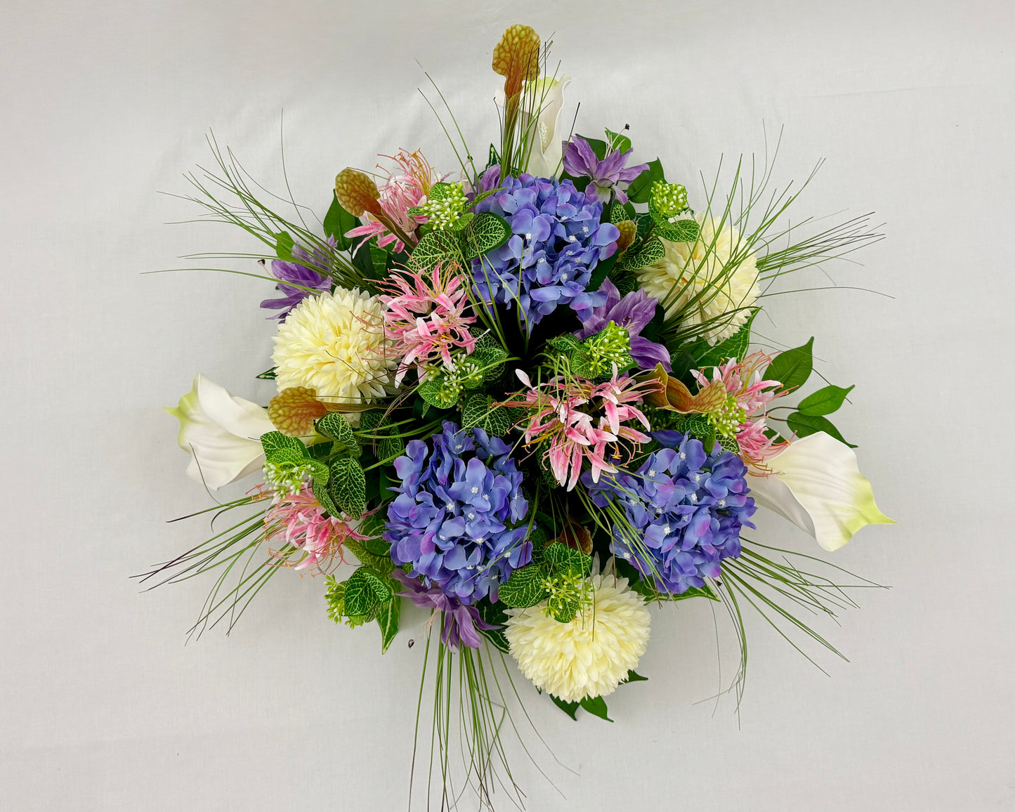 Rouwstuk met roze en paarse bloemen van boven gezien