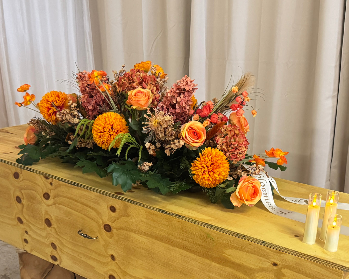 Oranje kiststuk op kist van kunstbloemen