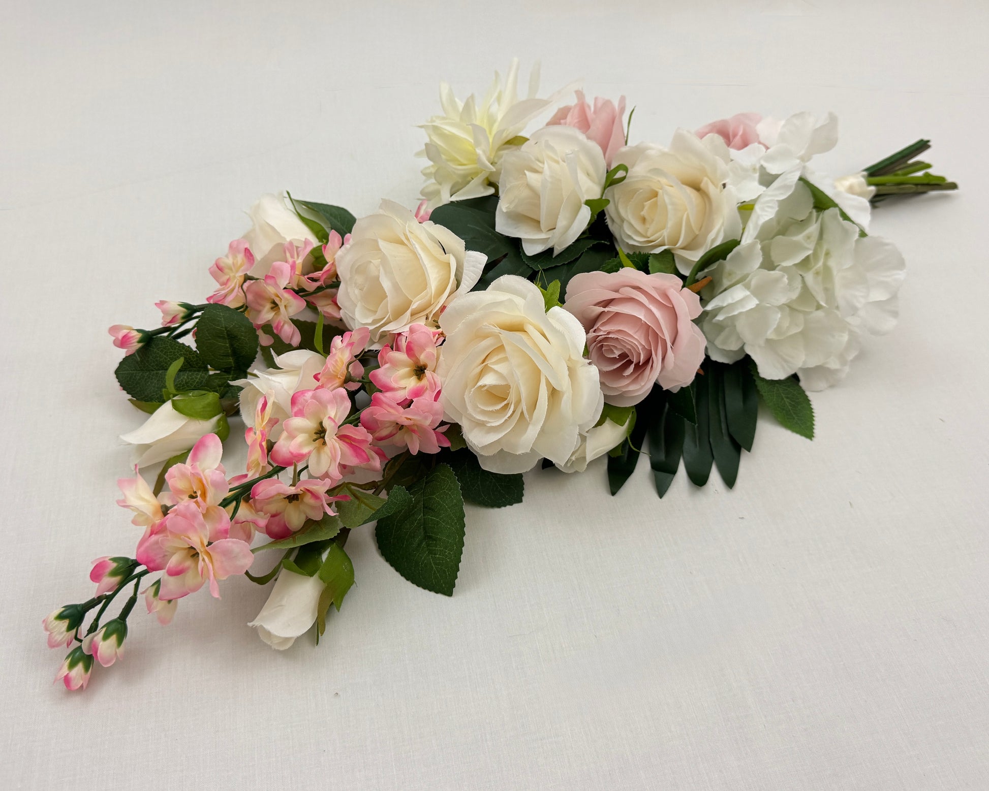 Liggend rouwboeket met roze en witte rozen