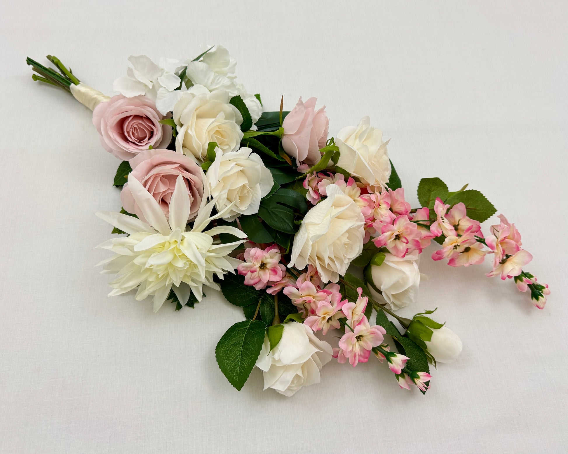 Liggend rouwboeket met roze en witte rozen
