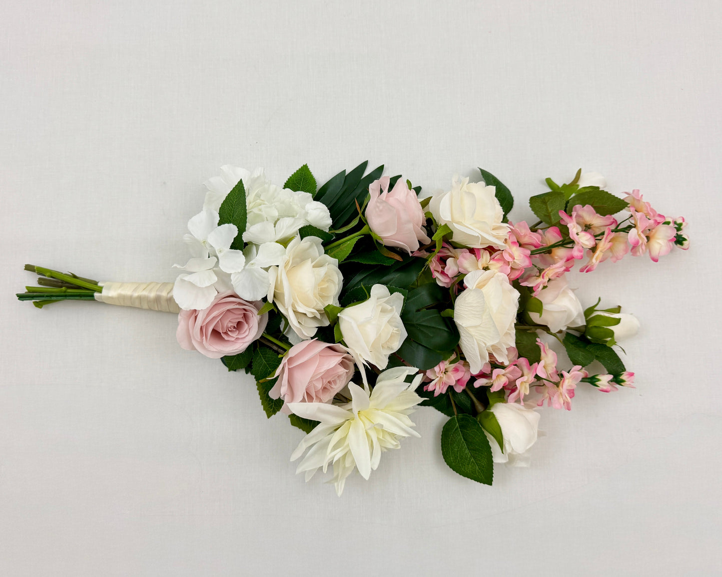 Liggend rouwboeket met roze en witte rozen