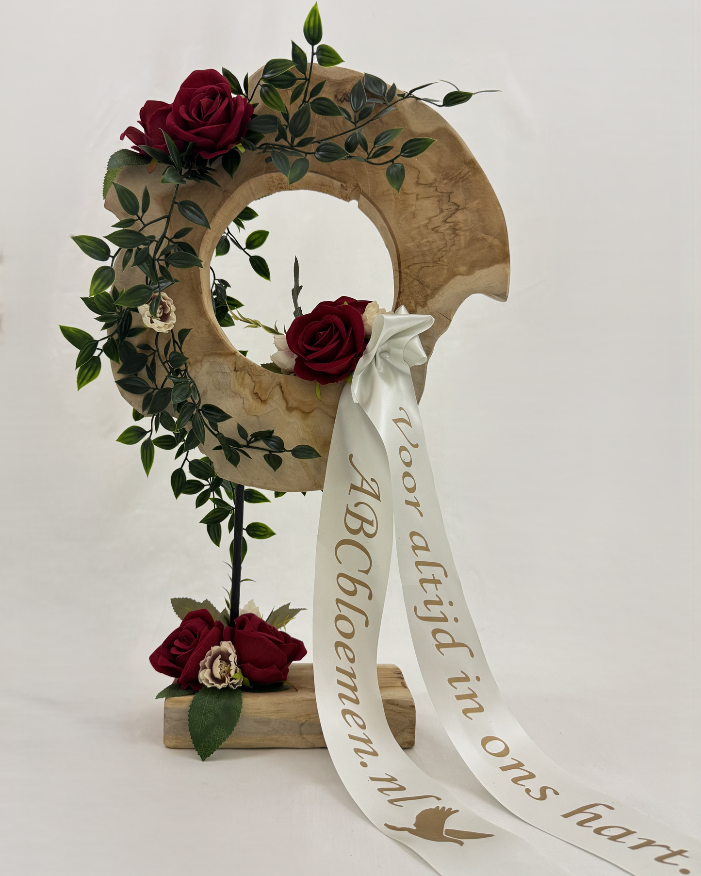 Rouwstuk op houten ornament met rode rozen