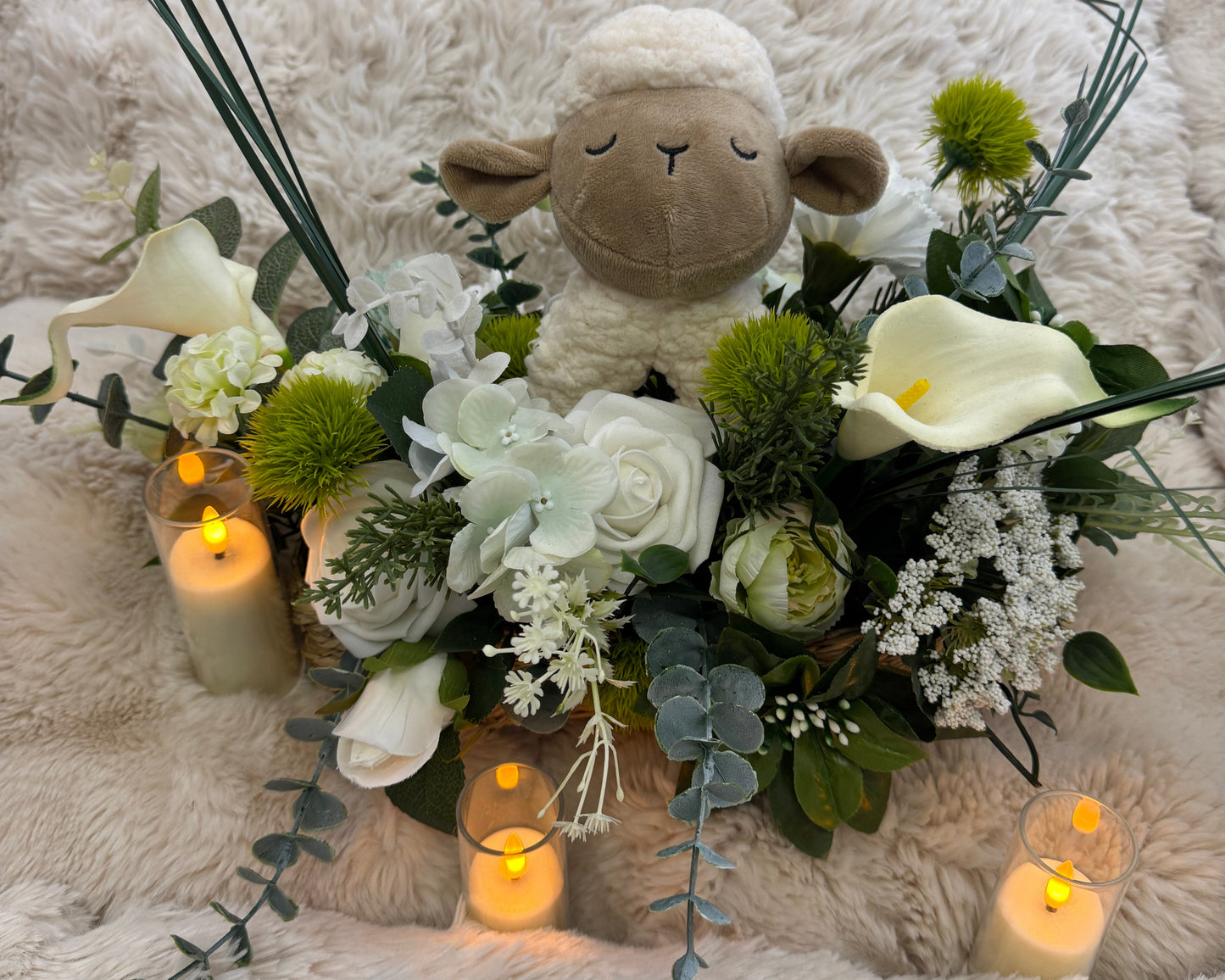 Rouwbloemen op een kussen met schaapje
