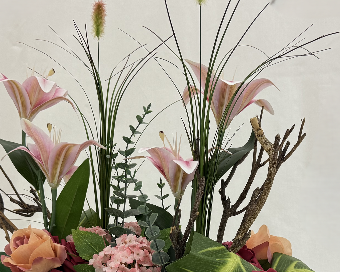 Close up van rouwboeket met lelies en grassprieten