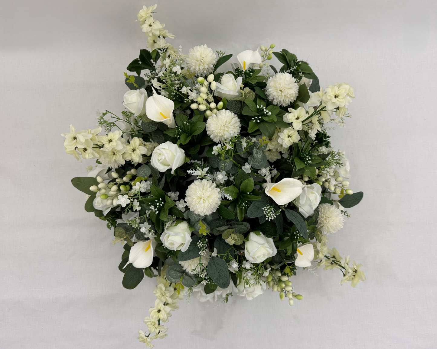 Biedermeier met witte rozen, dahlia's en calla's van boven gezien