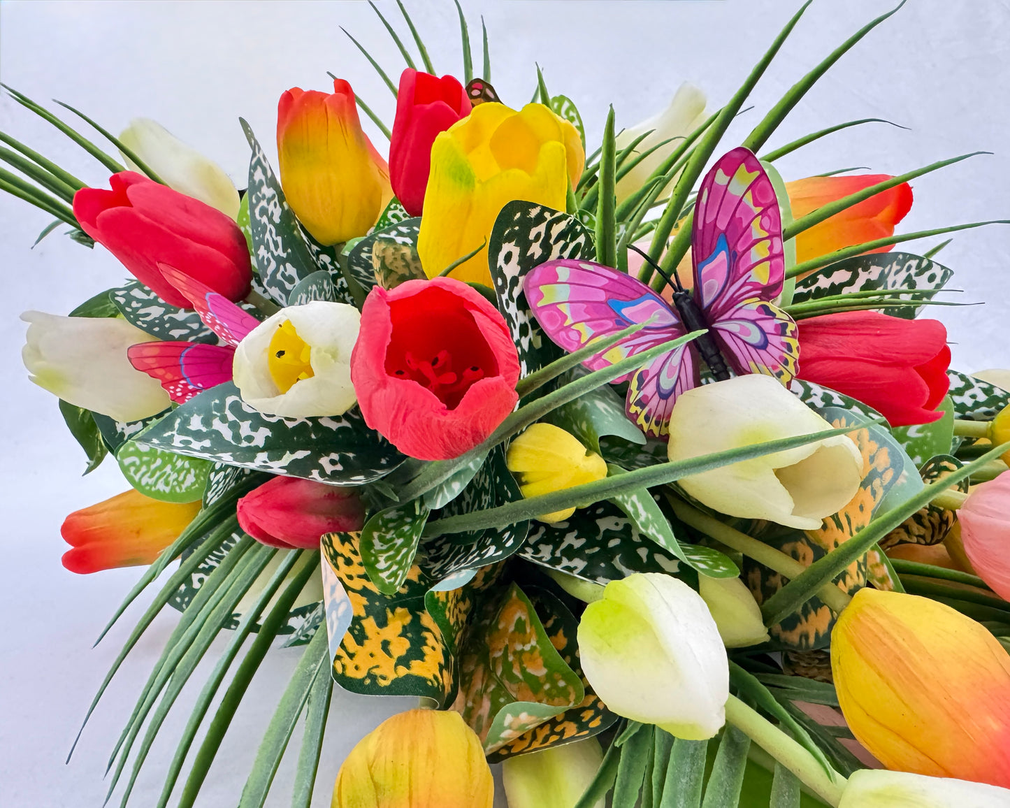 Close up van rouwboeket met tulpen en vlinders