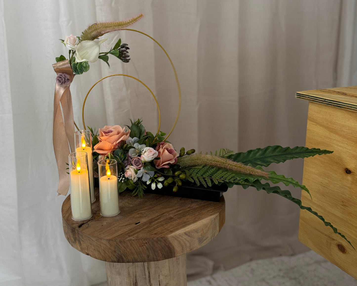 Sierlijk rouwstuk naast de rouwkist met kaarsen