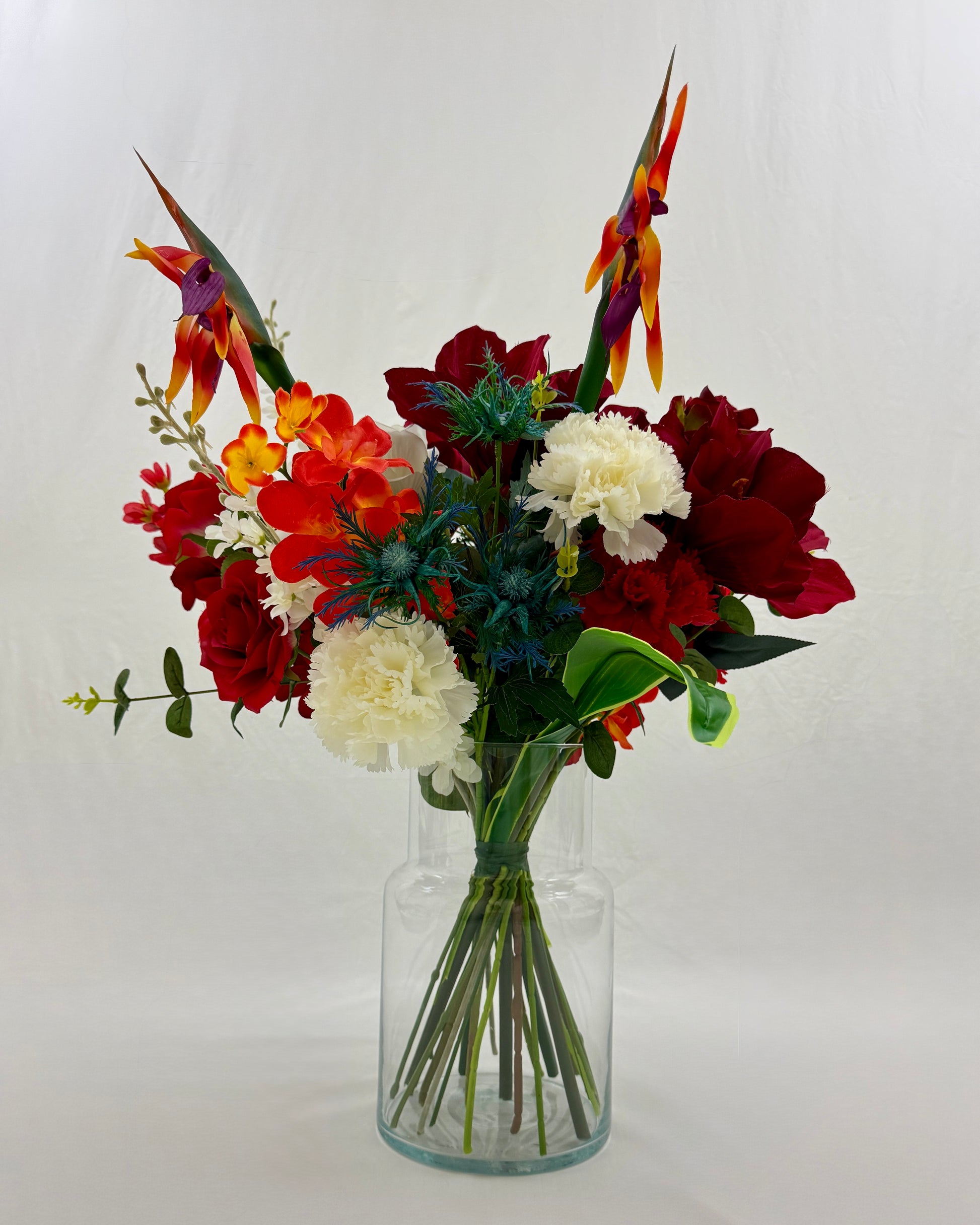 Staand rouwboeket met rode en witte bloemen in vaas