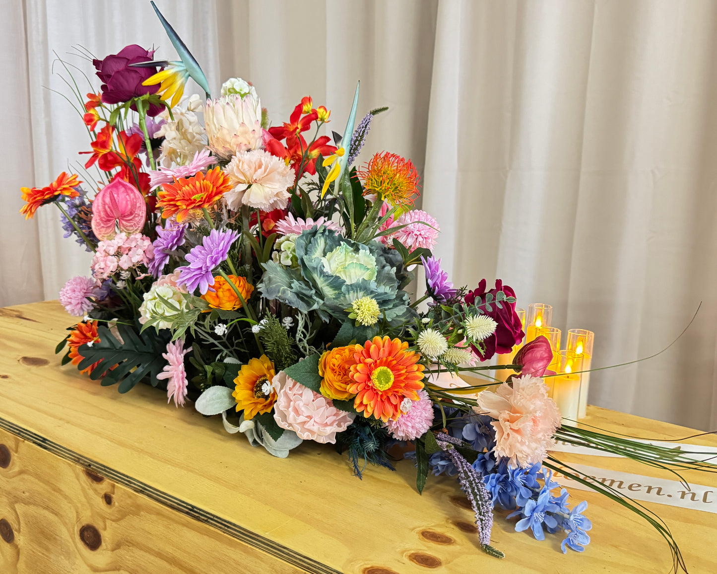 Groot rouwstuk op kist met diverse kleuren