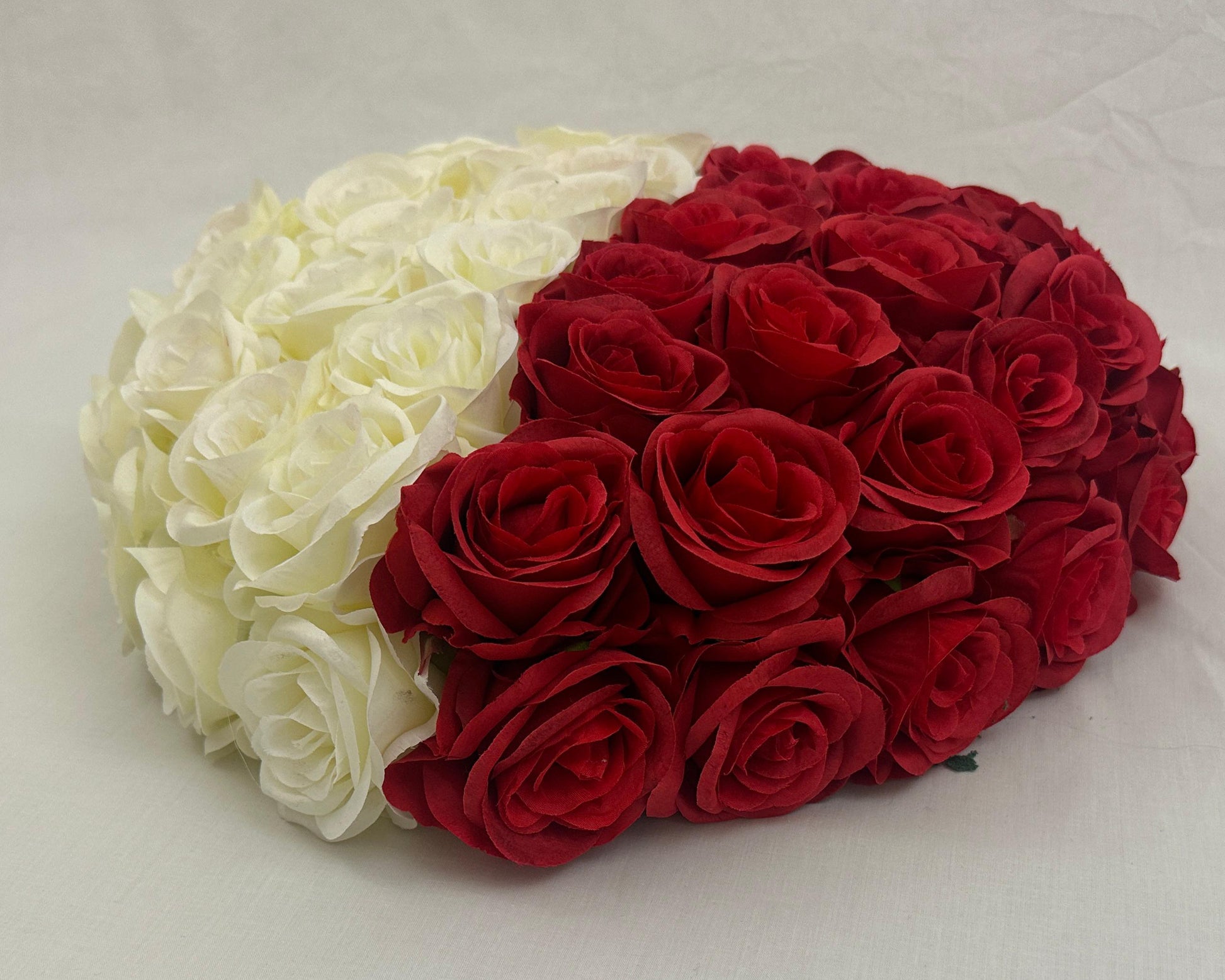 Rouwhart van witte en rode rozen