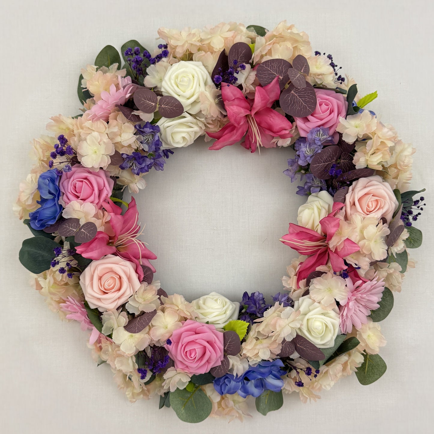 Sierlijke rouwkrans met roze en paarse bloemen