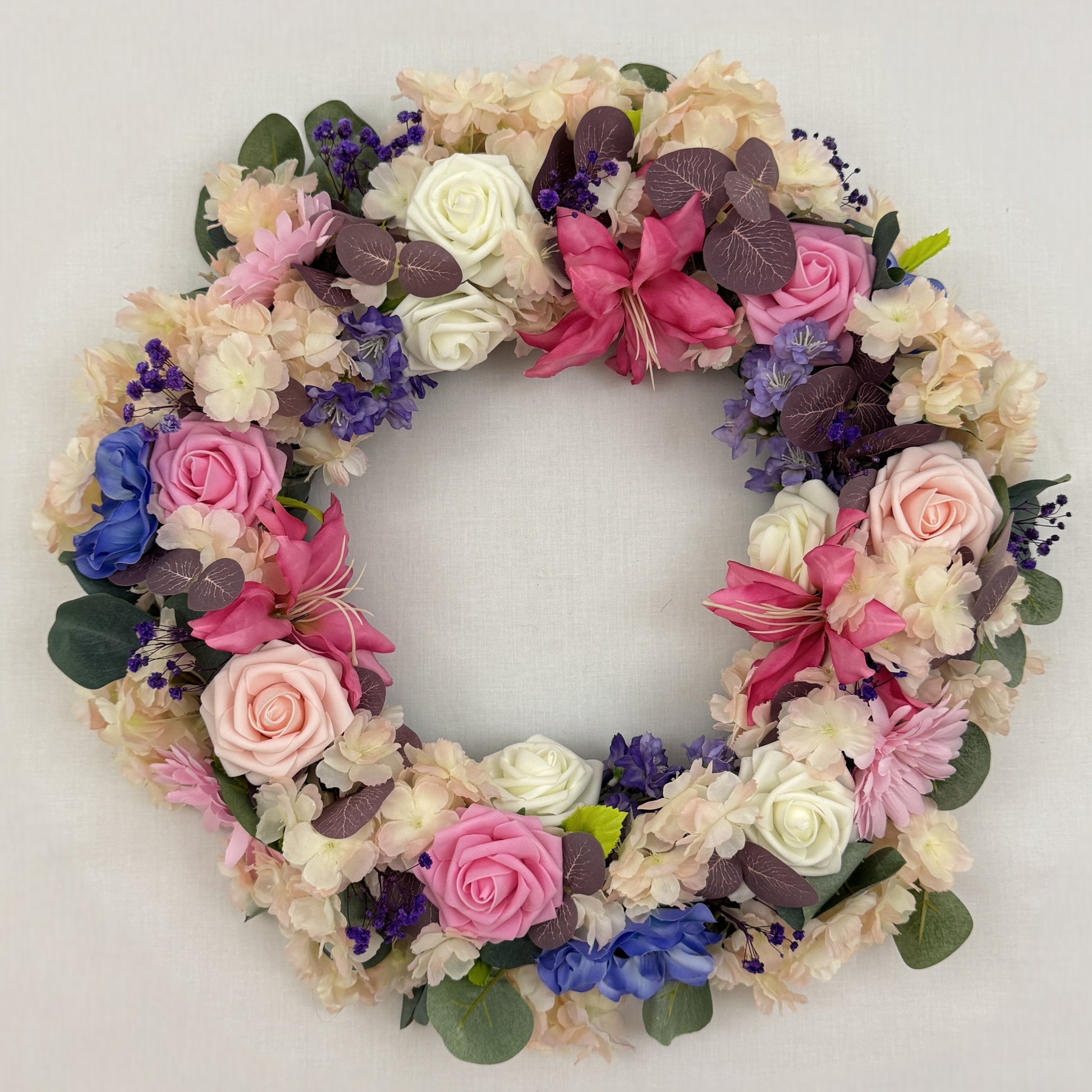 Sierlijke rouwkrans met roze en paarse bloemen