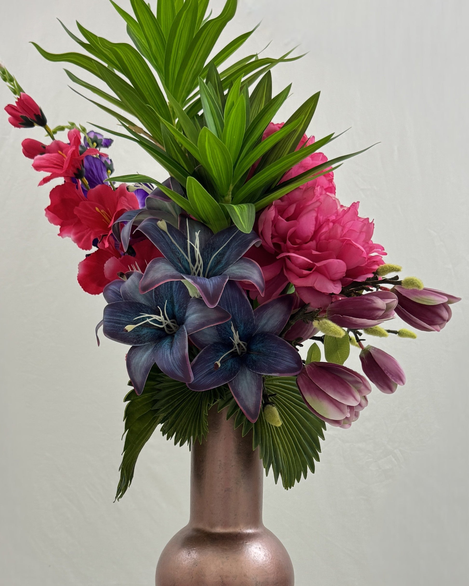 close-up van rouwboeket met donkere lelies en roze bloemen