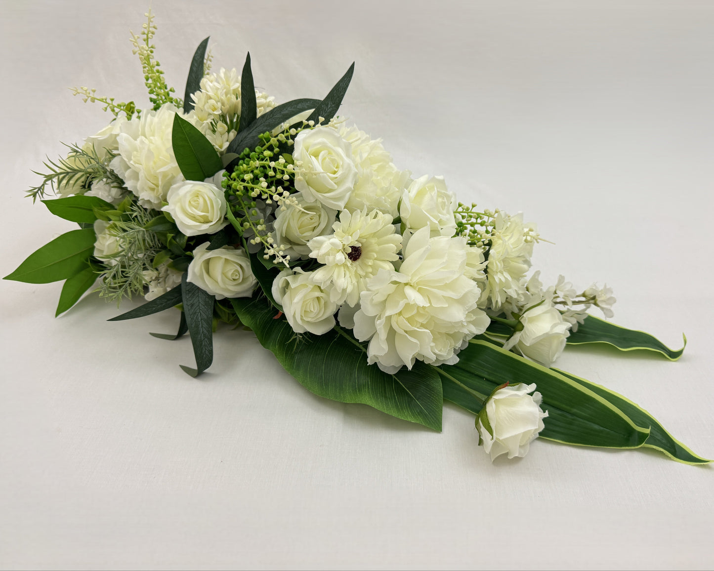 Druppelvormig sierlijk rouwboeket met witte bloemen