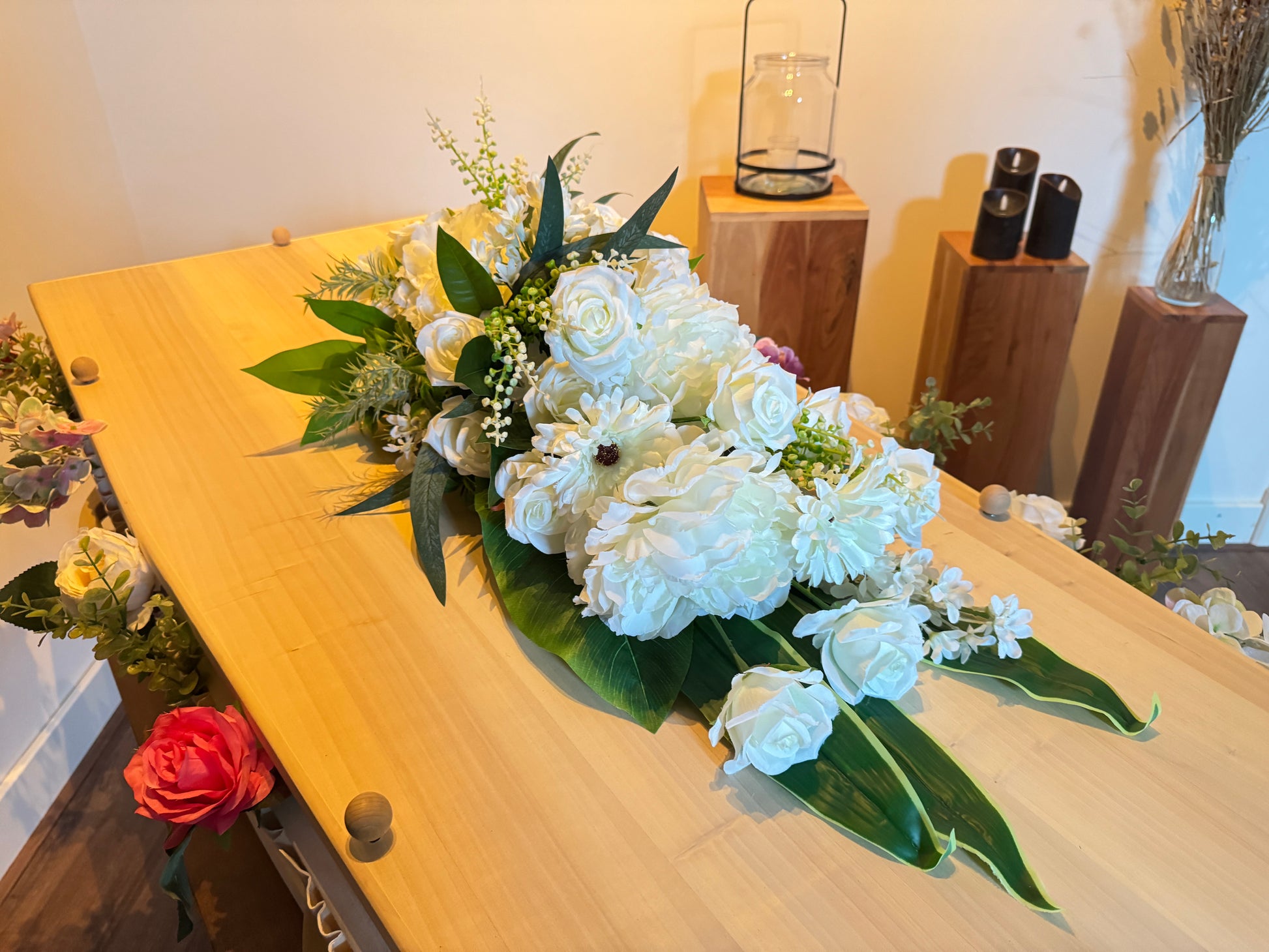 Wit druppelvormig rouwstuk op grafkist