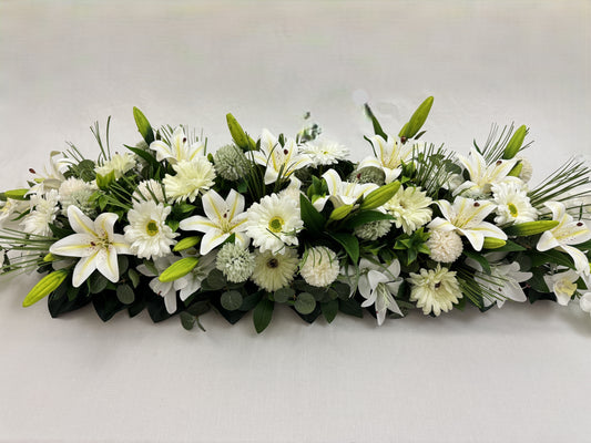 Close-up van langwerpig rouwstuk met witte bloemen