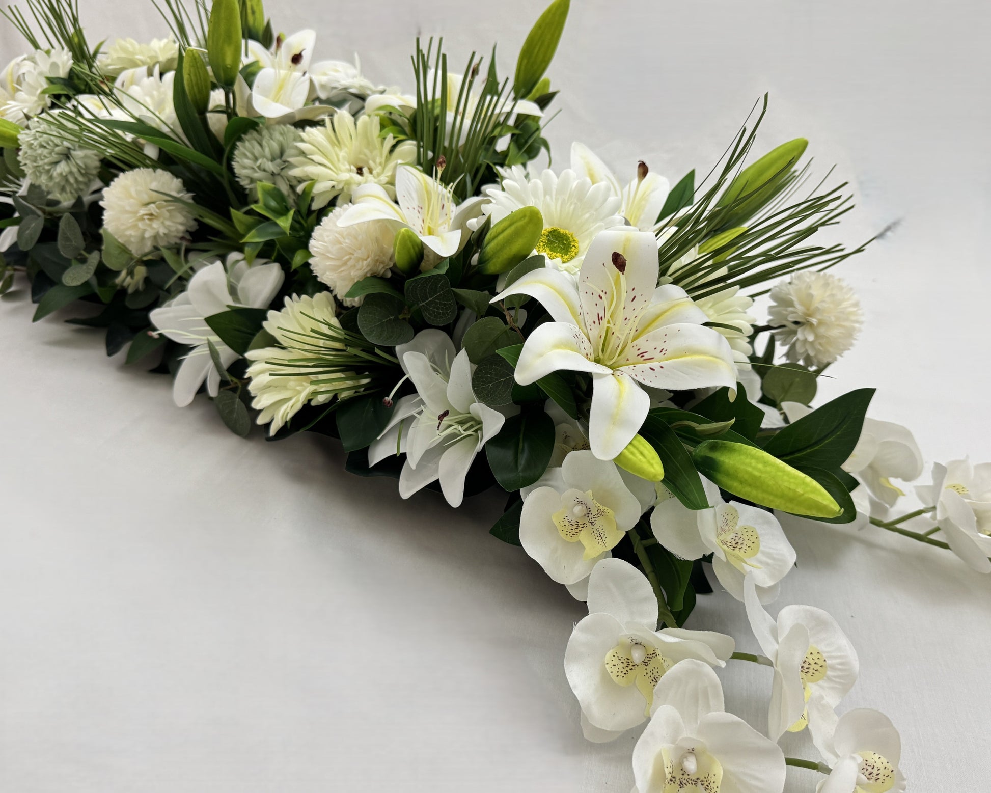 Rouwstuk met orchideeën en witte lelies