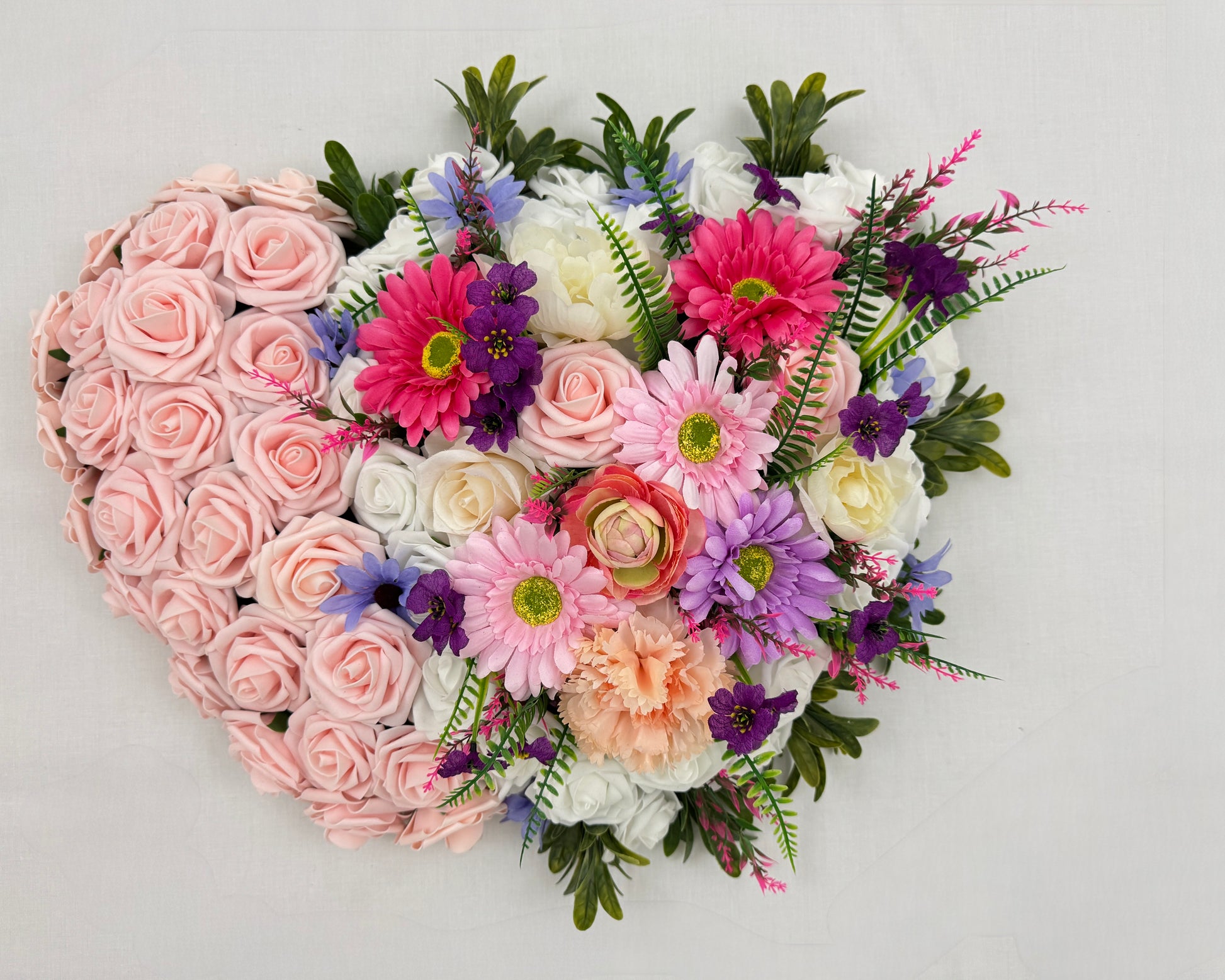 Dubbel rouwhart met roze rozen en andere bloemen
