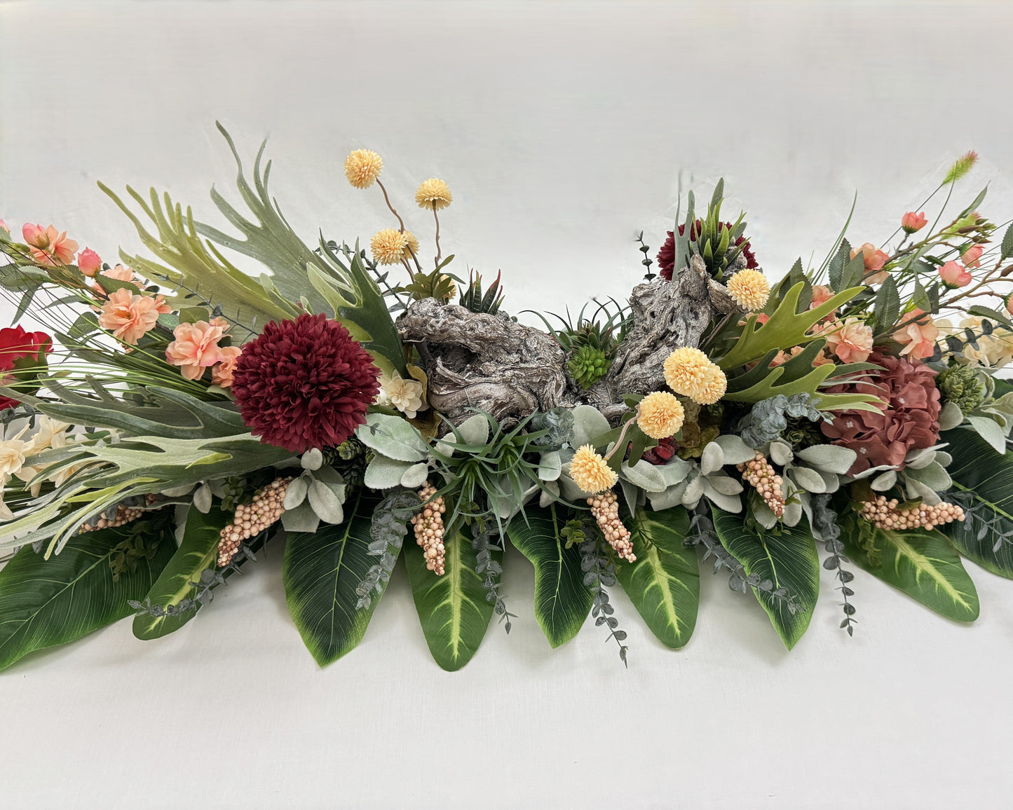 Rouwstuk voor op de kist met hout en vetplantjes erin verwerkt