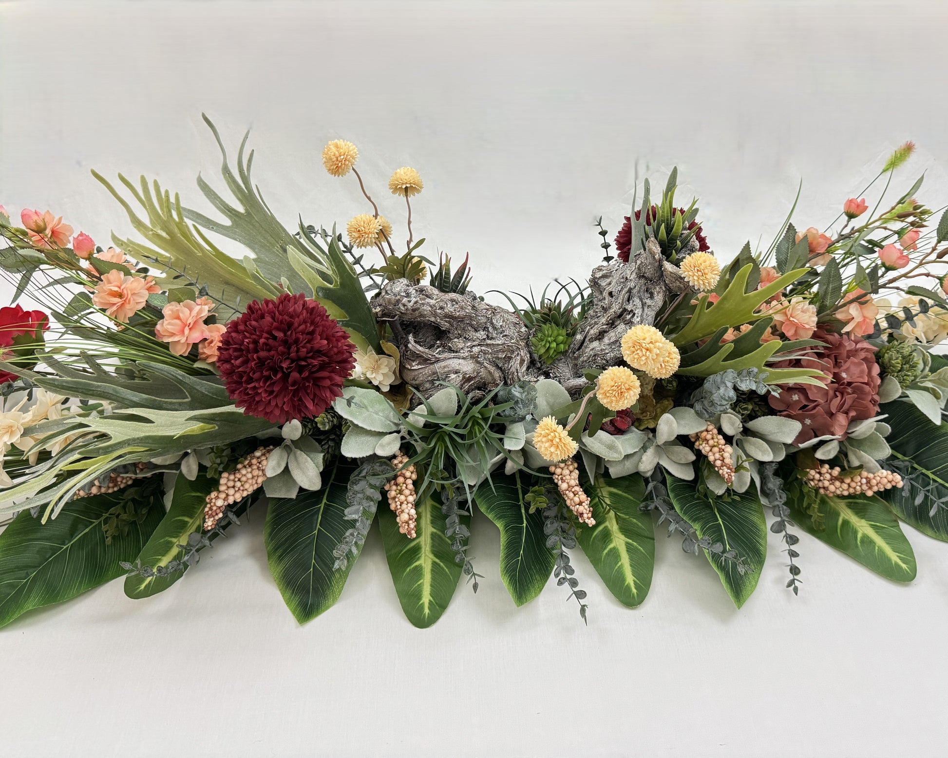 Rouwstuk voor op de kist met hout en vetplantjes erin verwerkt