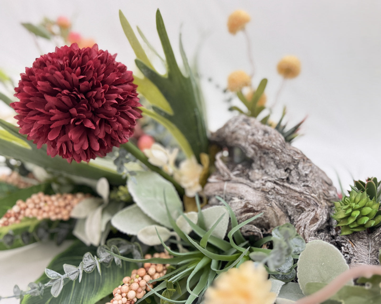 Close-up van rouwstuk met rode bloem en hout