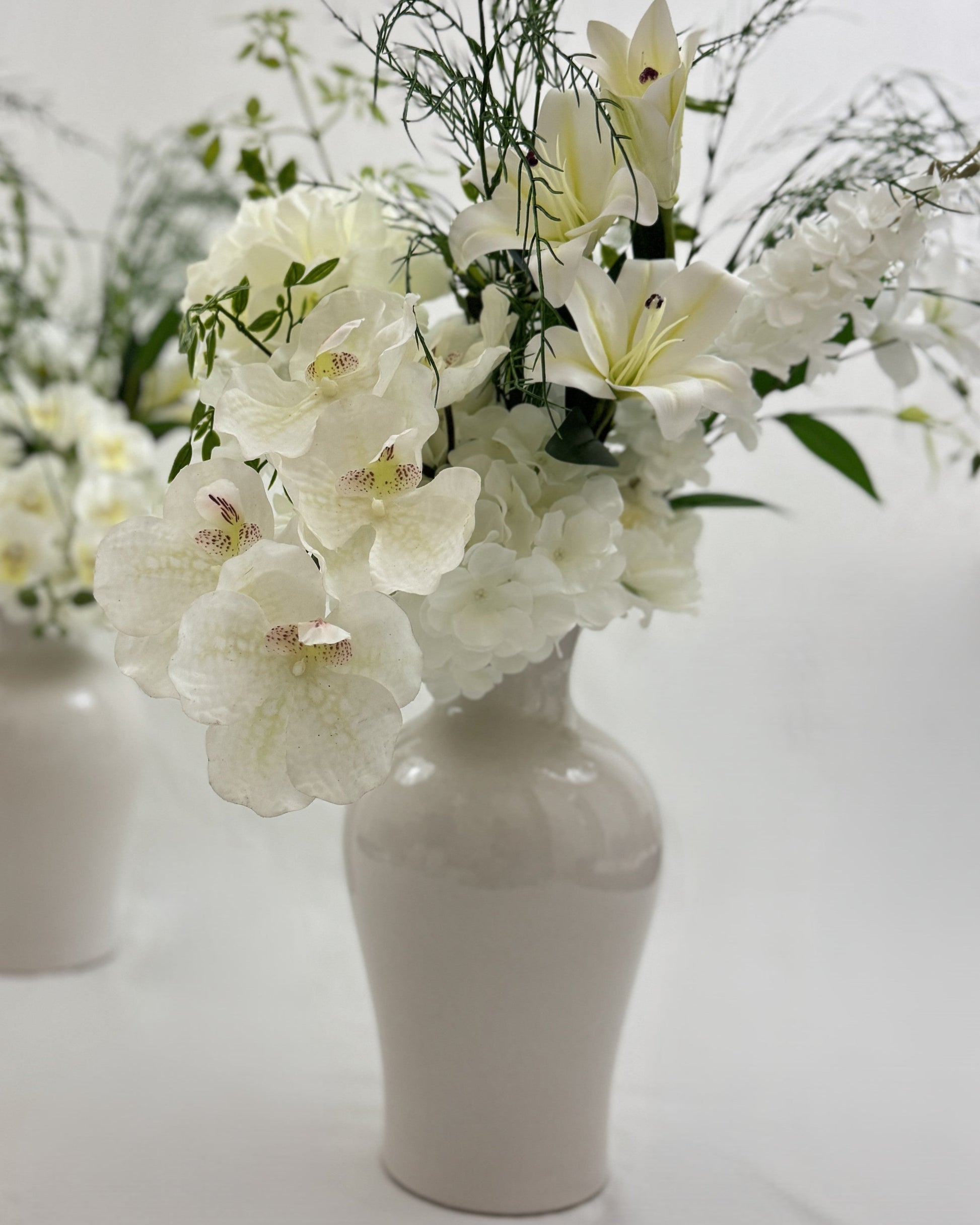 Rouwboeket met witte lelies, ridderspoor en orchidee