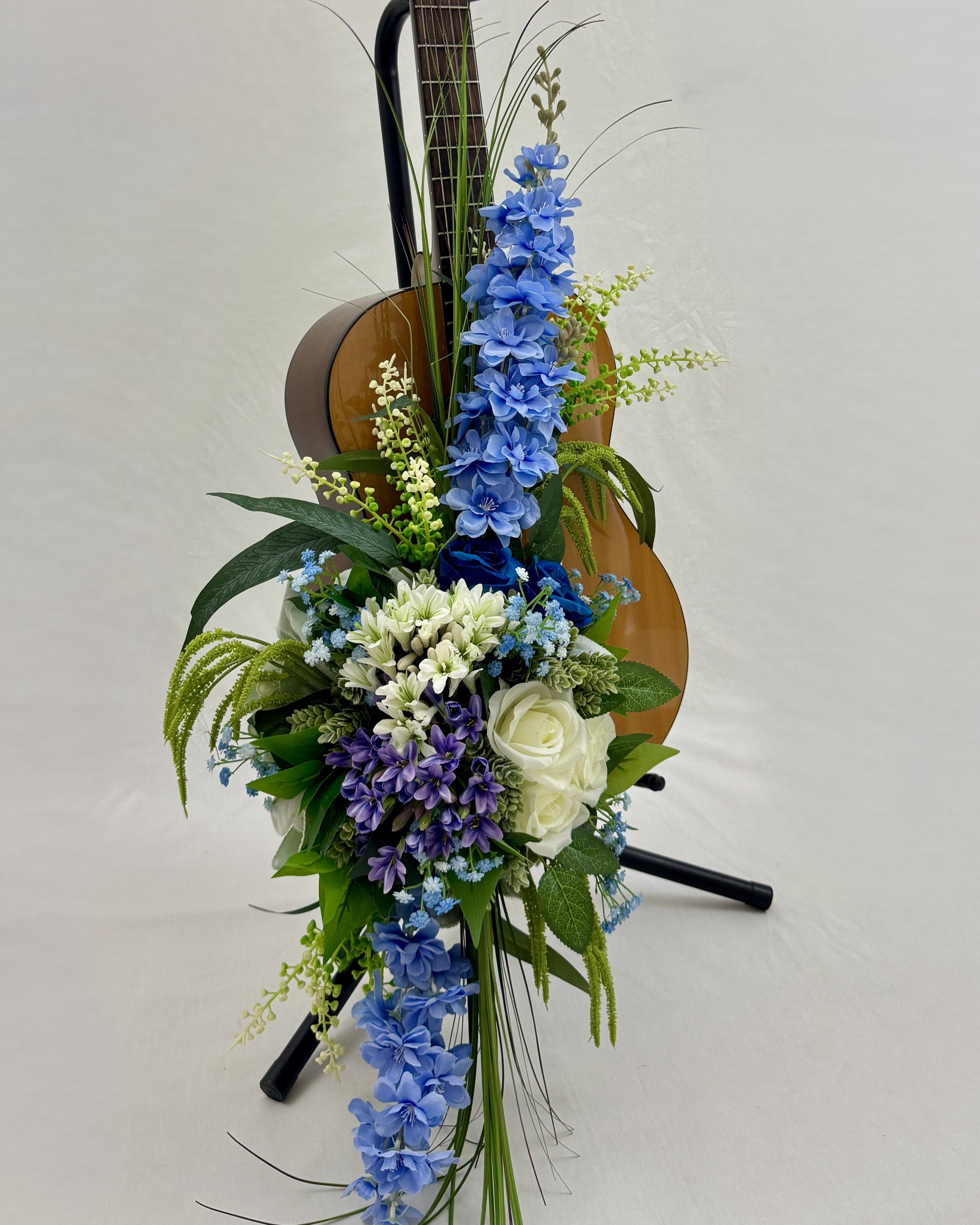 Rouwstuk met blauwe bloemen op gitaar