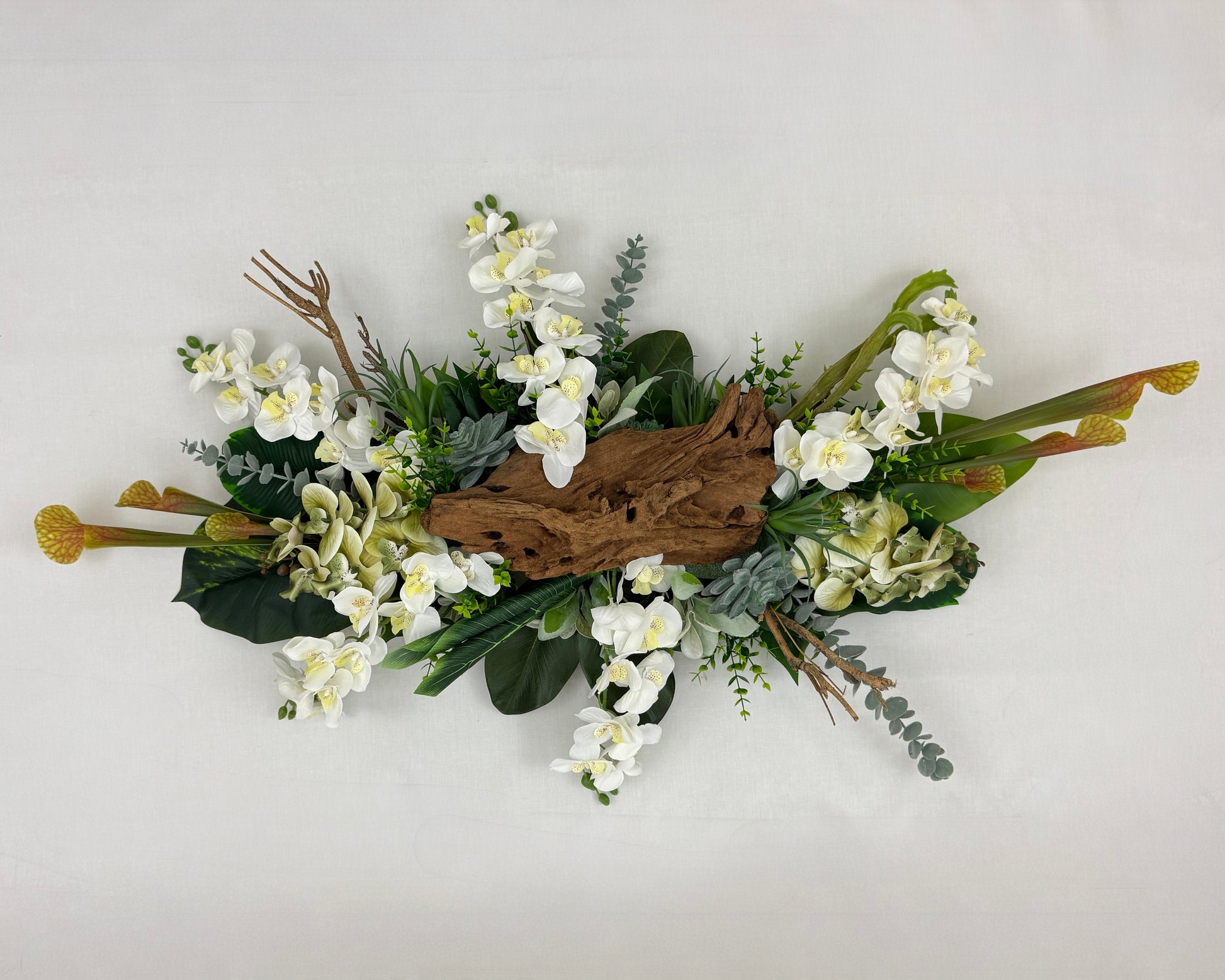 Rouwstuk met witte bloemen en hout van boven gezien