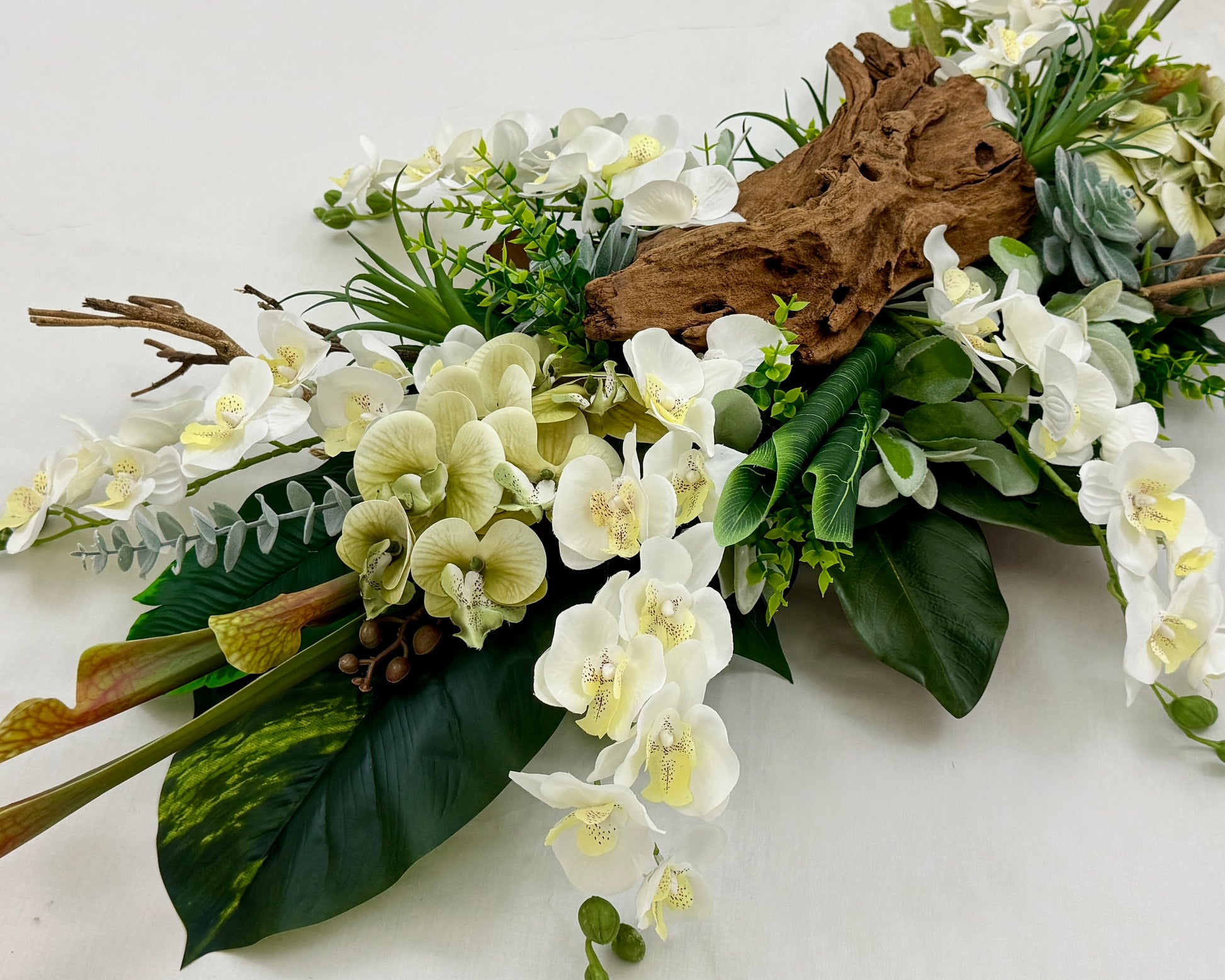 Rouwstuk met hout en witte orchideeën