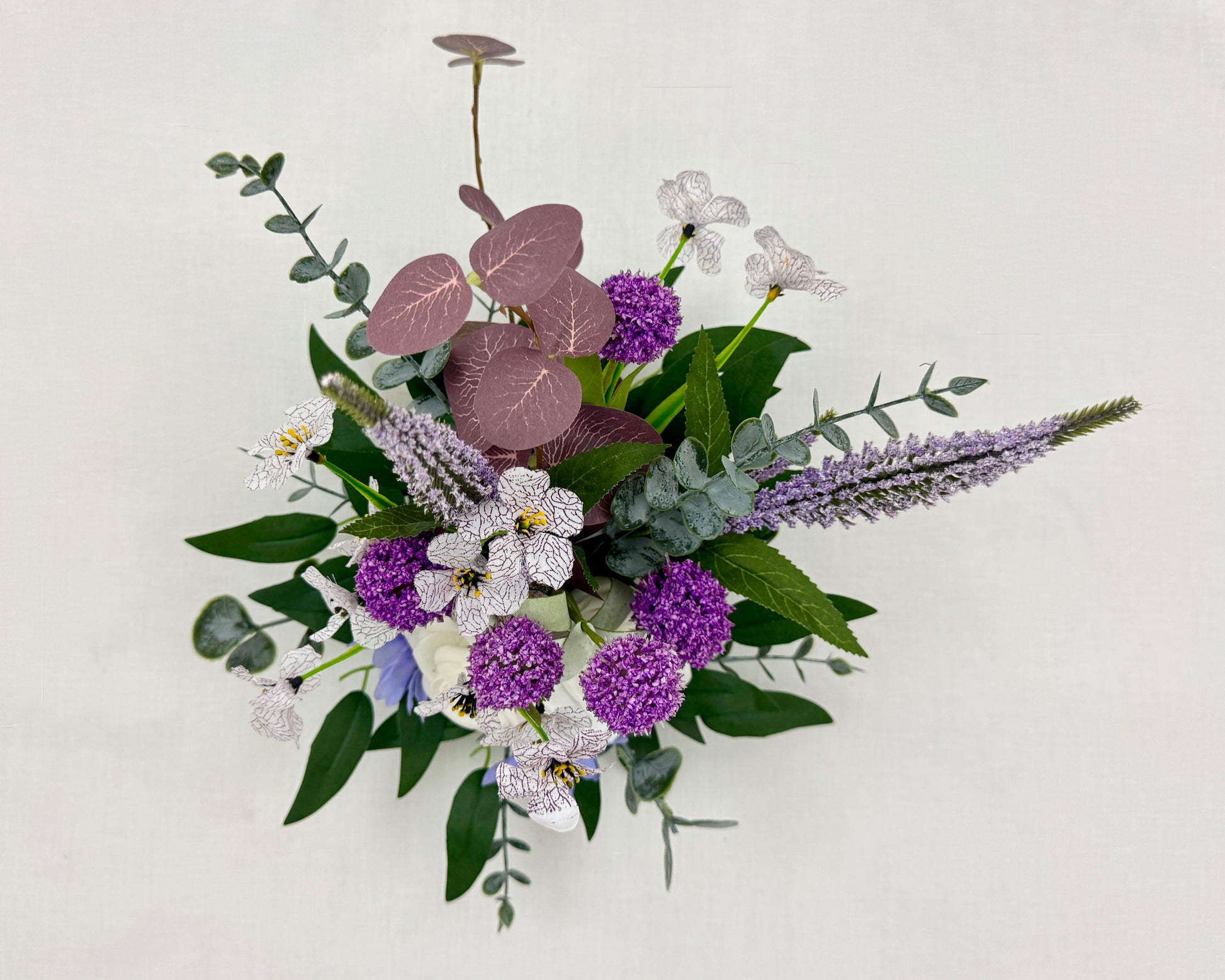 Mini rouwboeket met lila bloemen van boven gezien