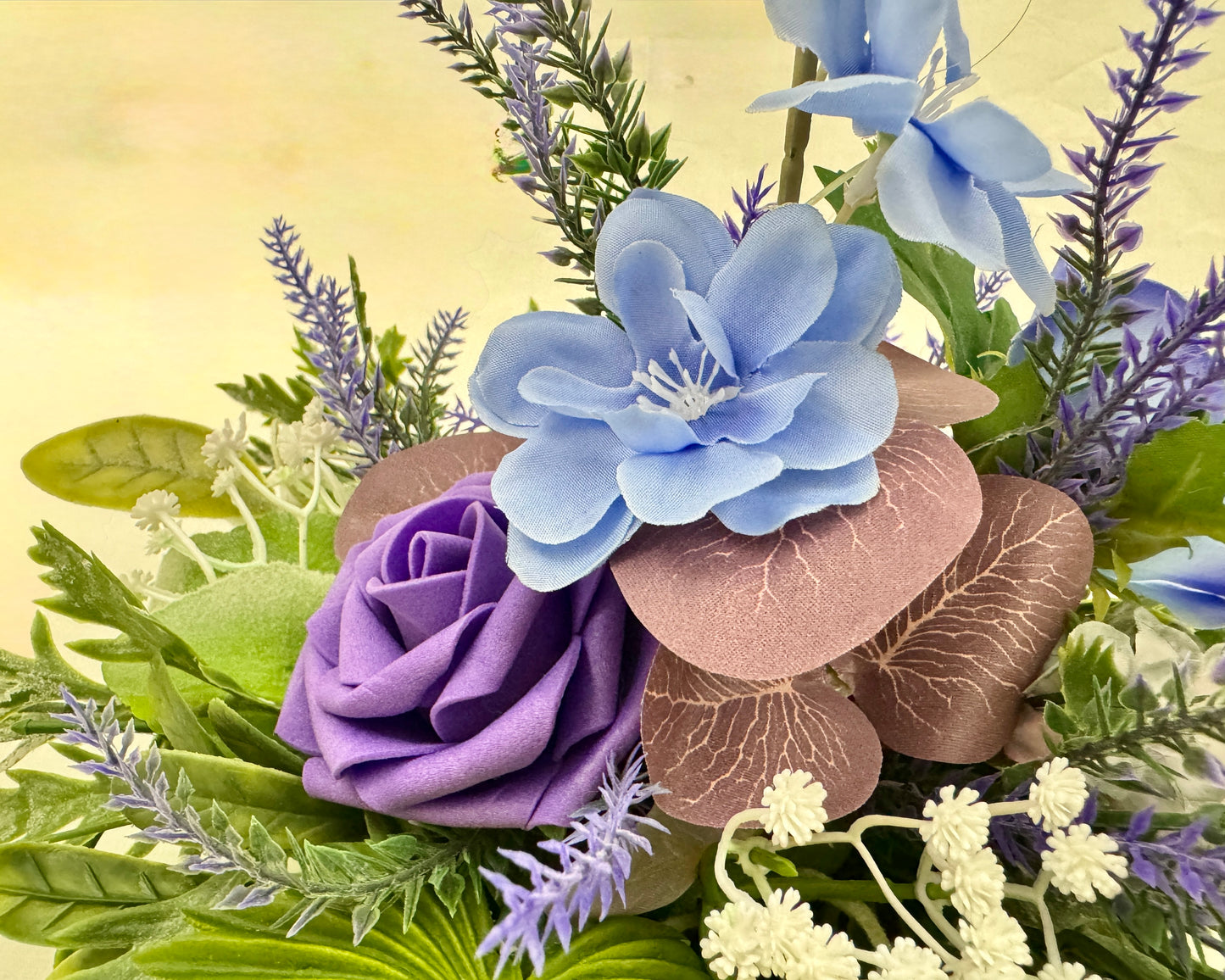 Close up van mini rouwboeket met paarse bloemen