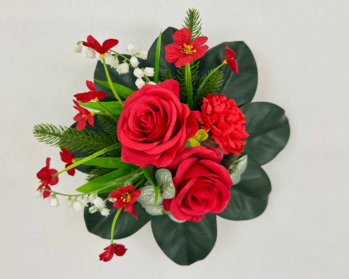 mini rouwboeket met rode rozen van boven gezien