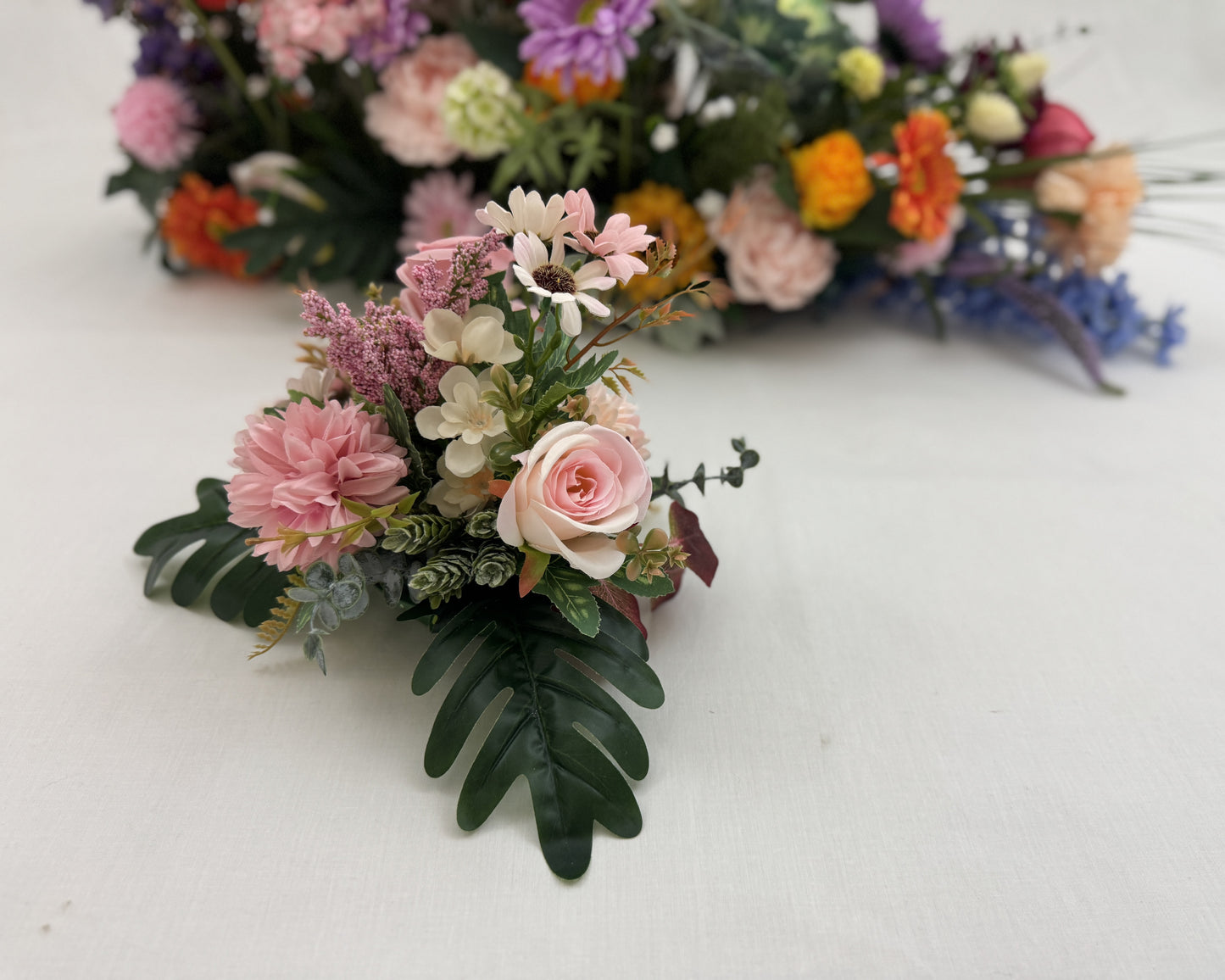 Mini-boeket roze bloemen met groot rouwstuk op achtergrond 