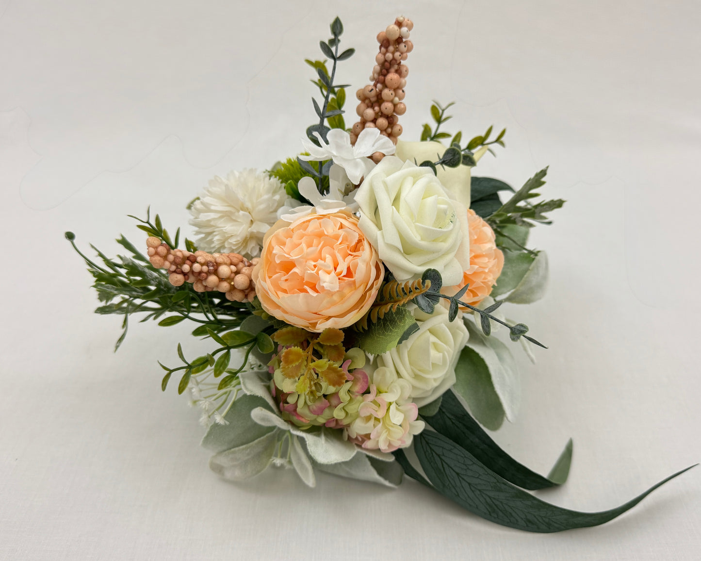 mini rouwboeket met zalmroze kleuren en besjes